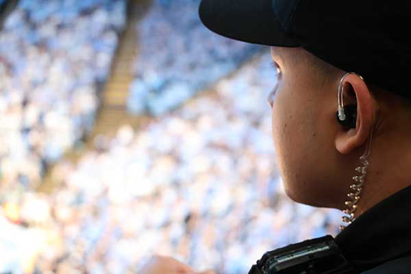 An officer monitors fan activity from an entry point in the stands.